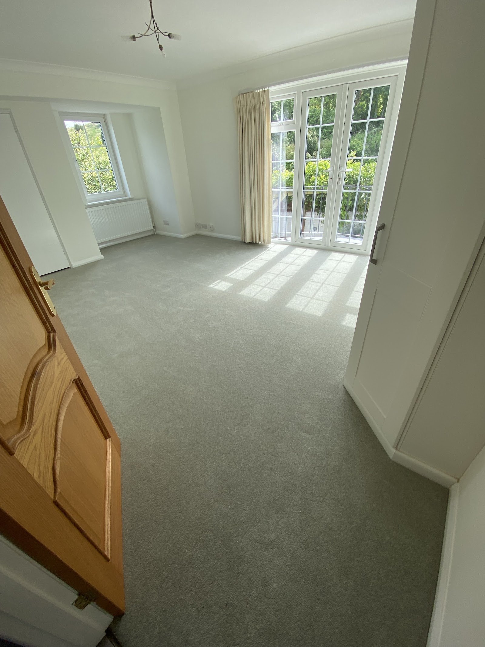 Newly carpeted bedroom with garden doors