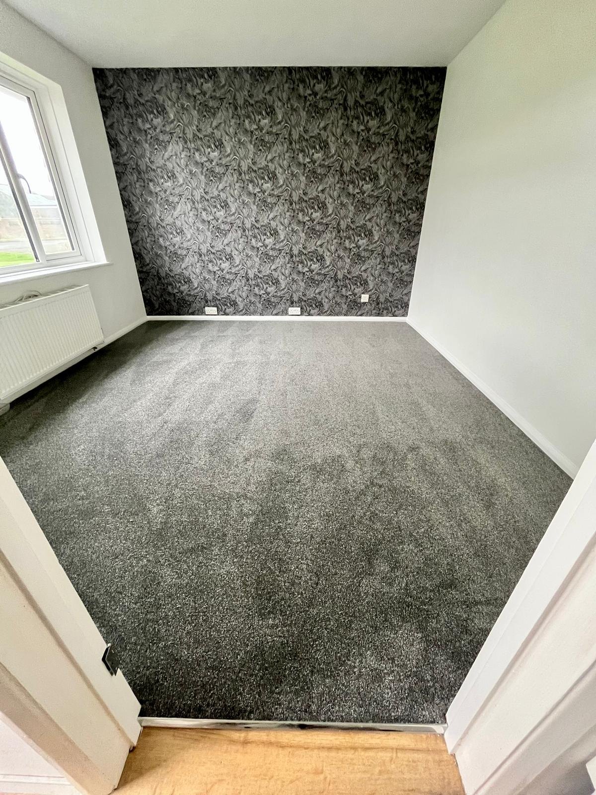 Charcoal carpet in a room with a patterned feature wall