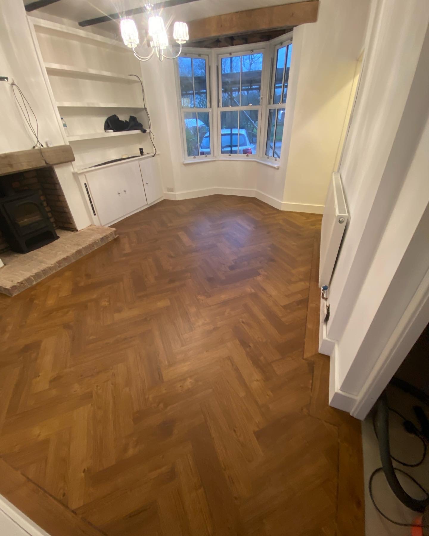 Warm oak herringbone floor around a log burner hearth