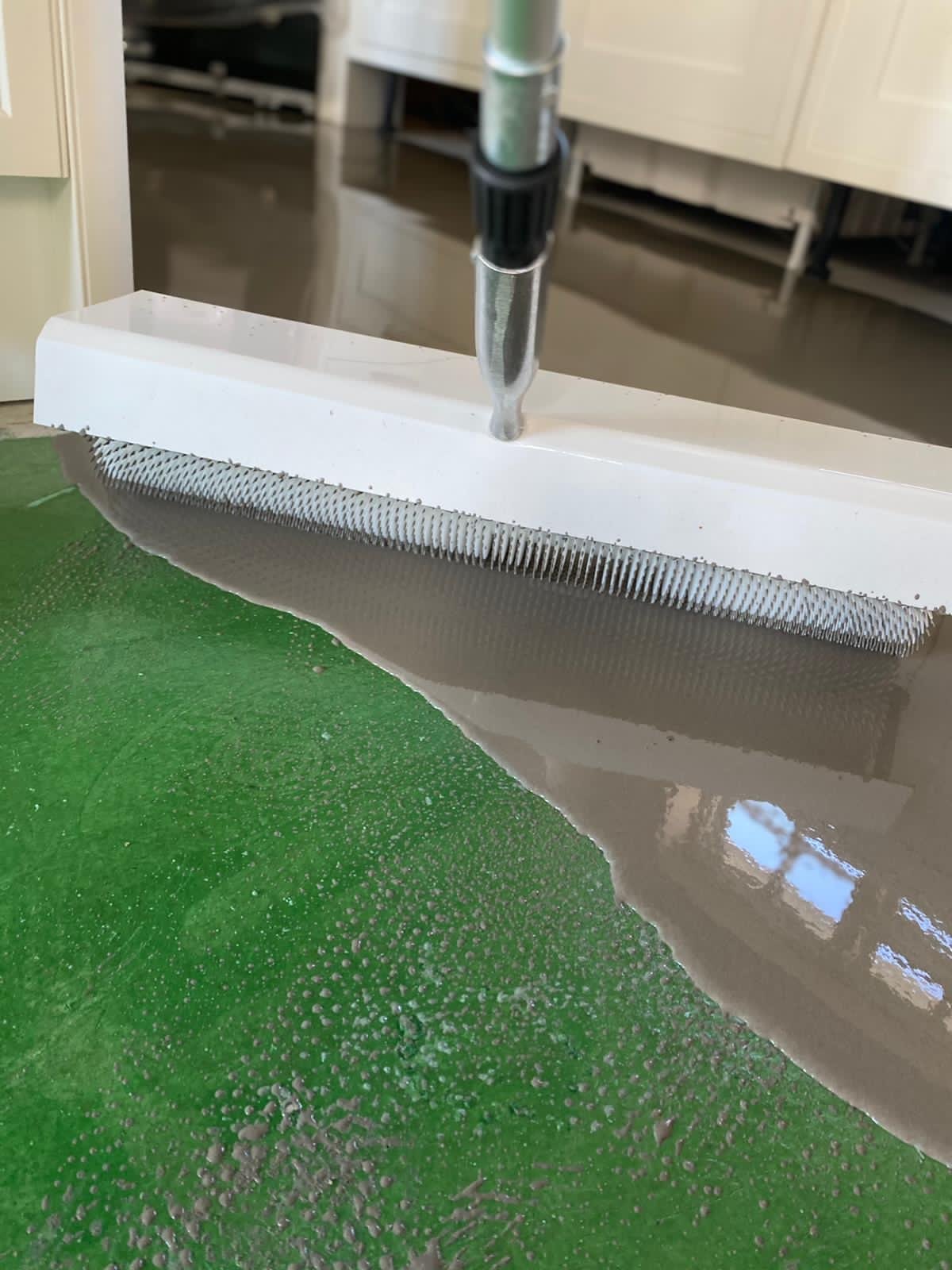 Levelling compound being spread with a spiked roller