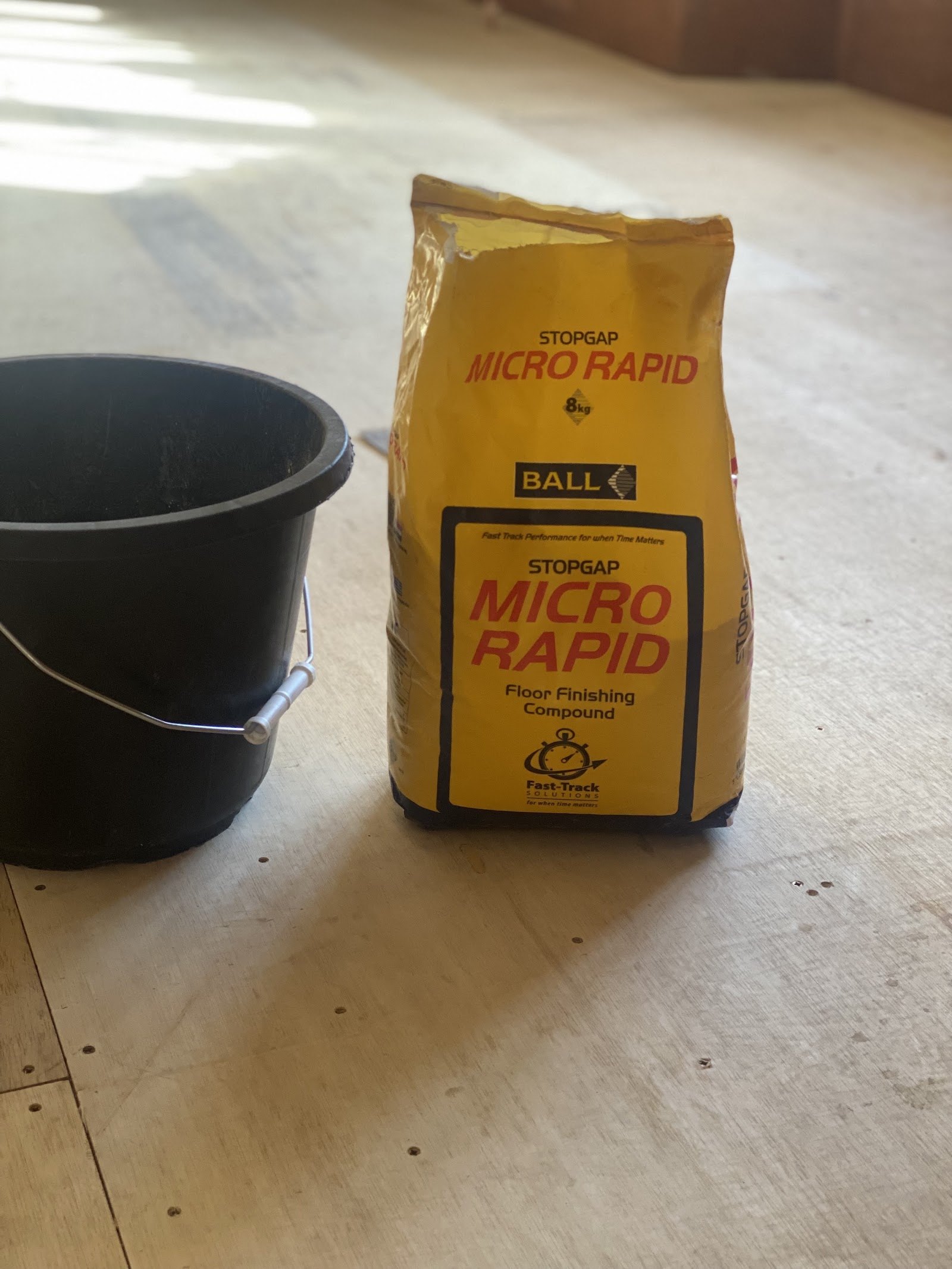 Bag of rapid-setting floor levelling compound on a prepared floor