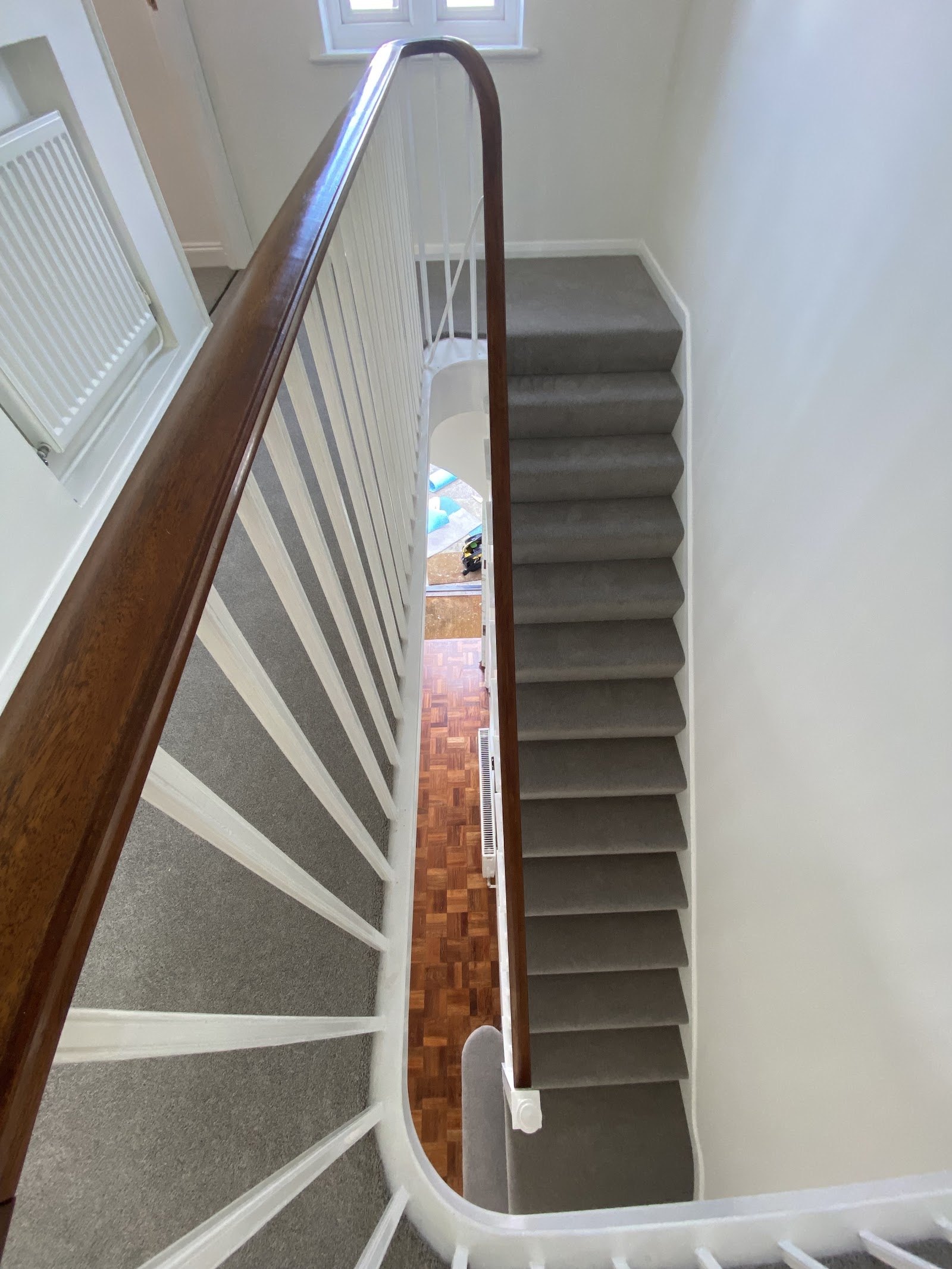 Grey carpet on a tall staircase seen from the landing