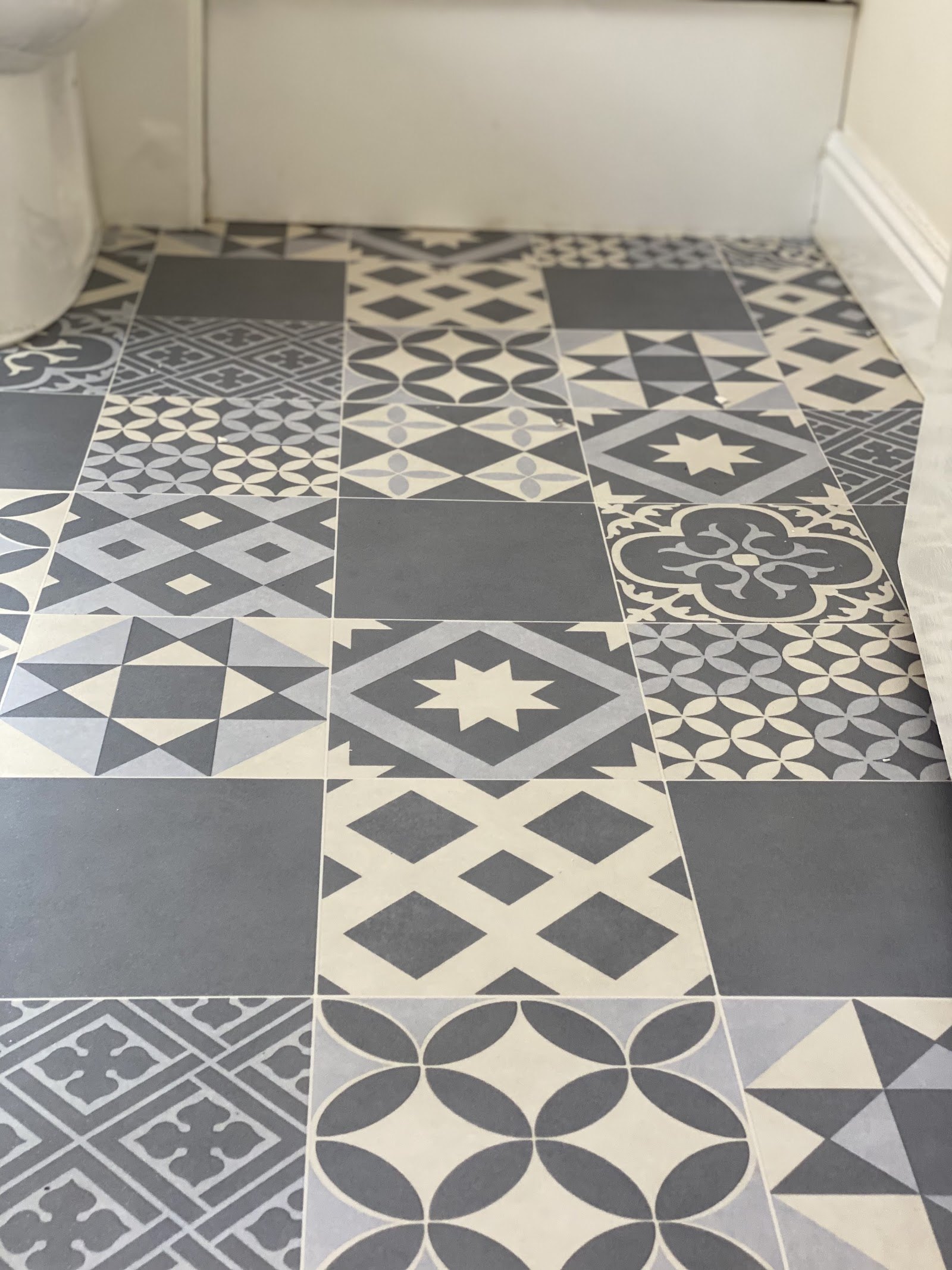 Patterned grey and white vinyl floor tiles in a bathroom