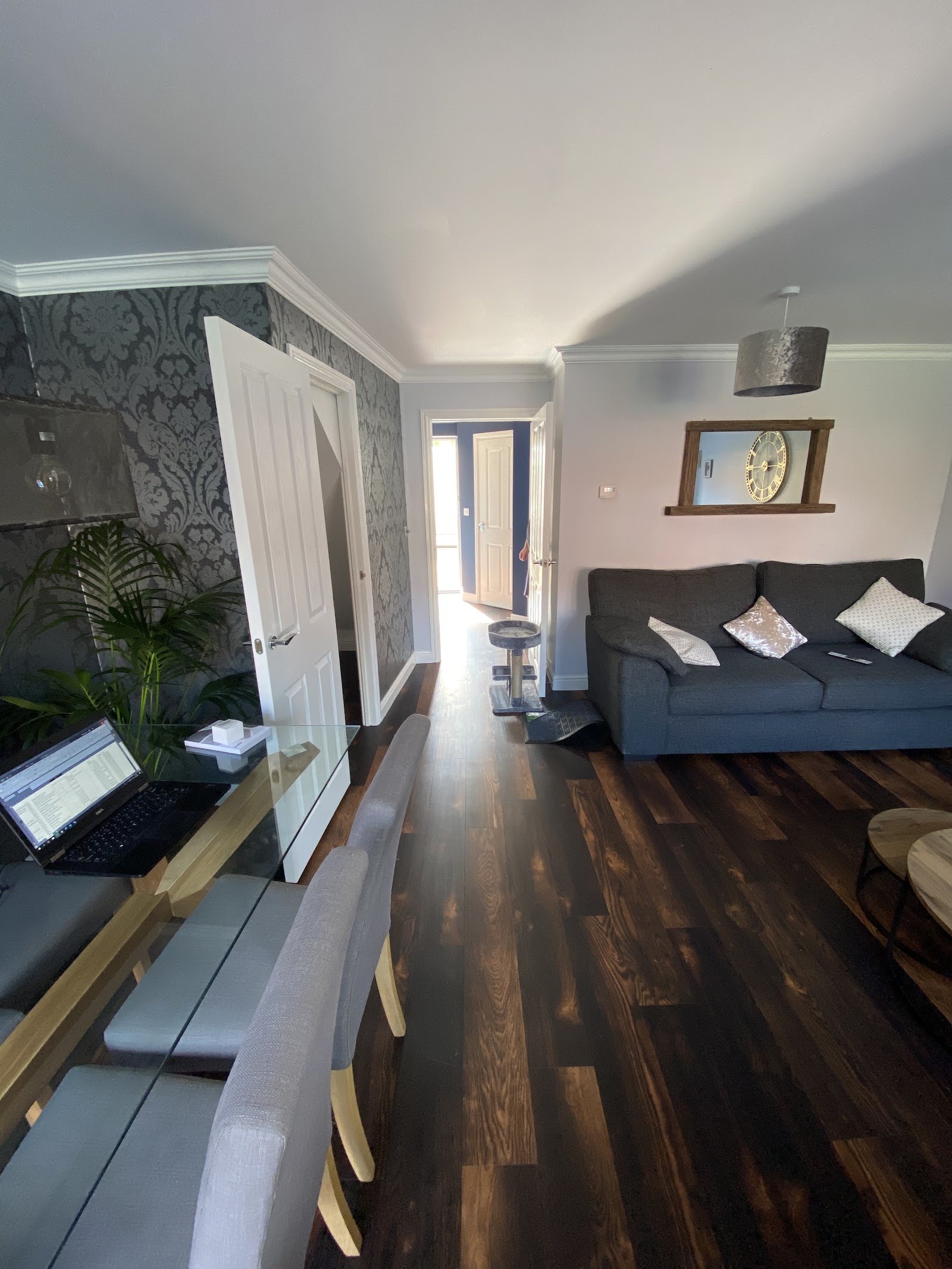 Dark wood-effect floor through a lounge and dining area