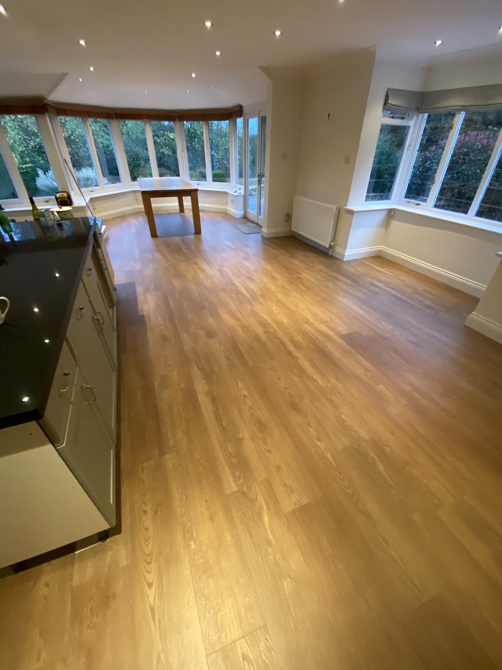 Oak-effect floor in an open room with a curved bay