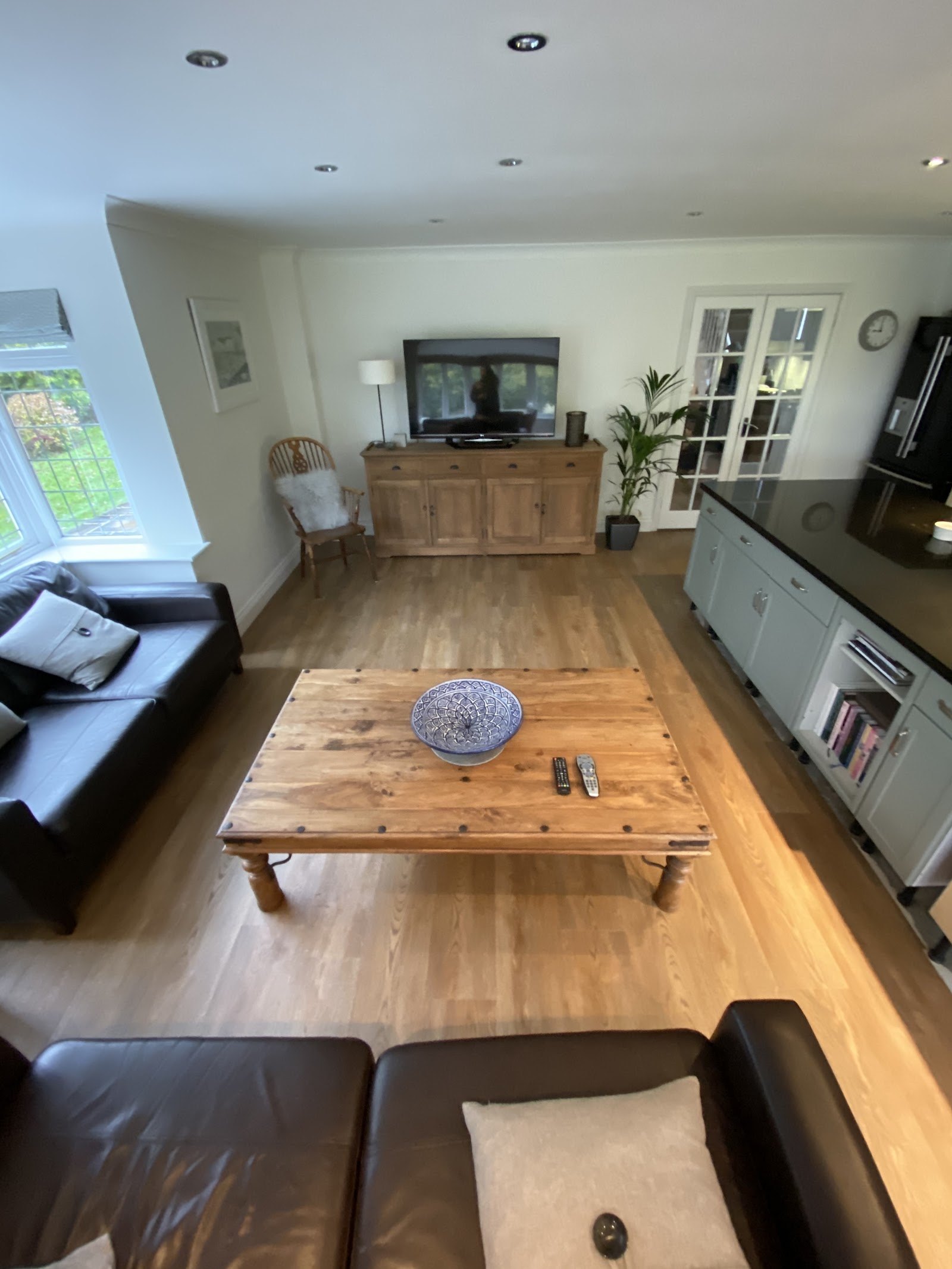 Living room with warm oak-effect floor and leather sofas