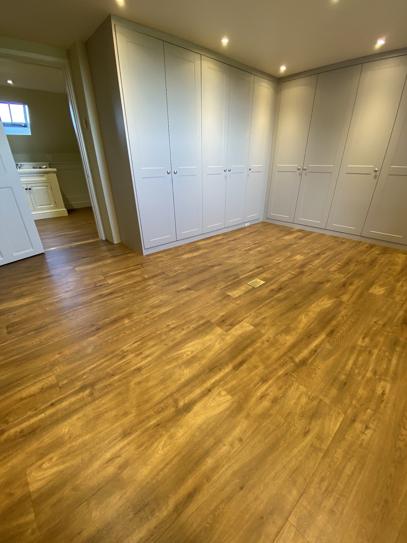 Warm oak-effect floor in a room with fitted wardrobes